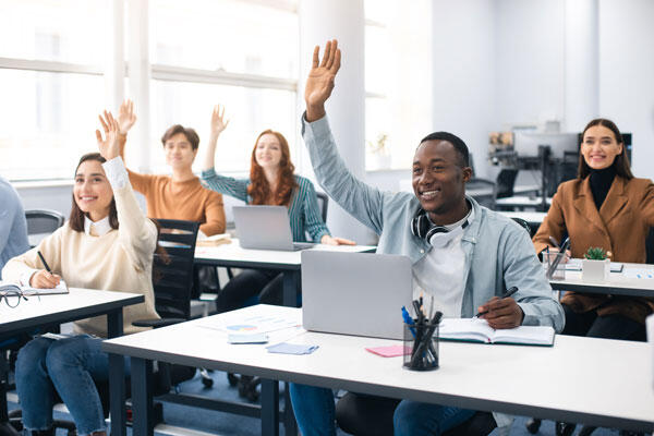 Students in a classroom raising hands