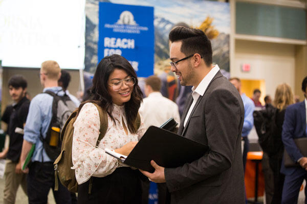 Student speaking with a faculty member at an event