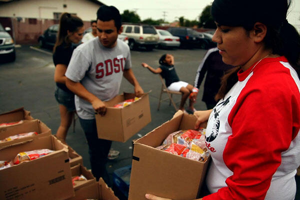 Student volunteers carrying and loading food boxes